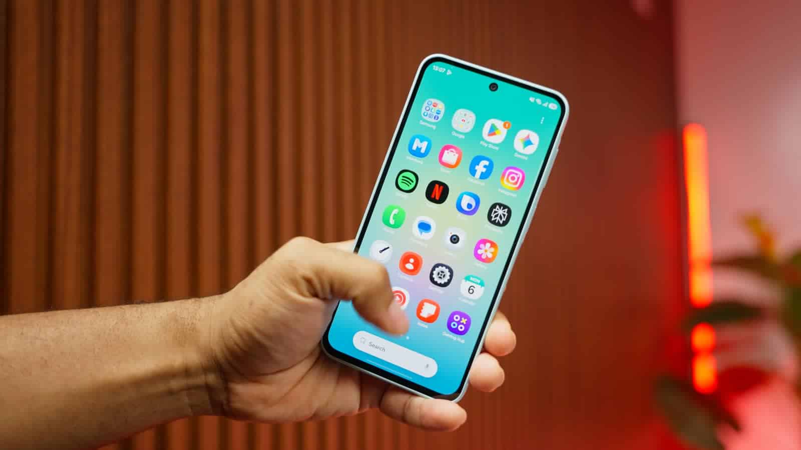 The Galaxy A27's screen with its punch-hole camera, held in one hand