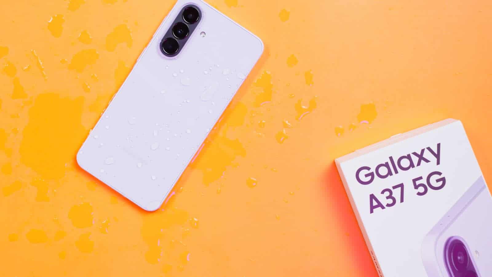 The Galaxy A37 5G in lilac with water splashed across its back, beside its box
