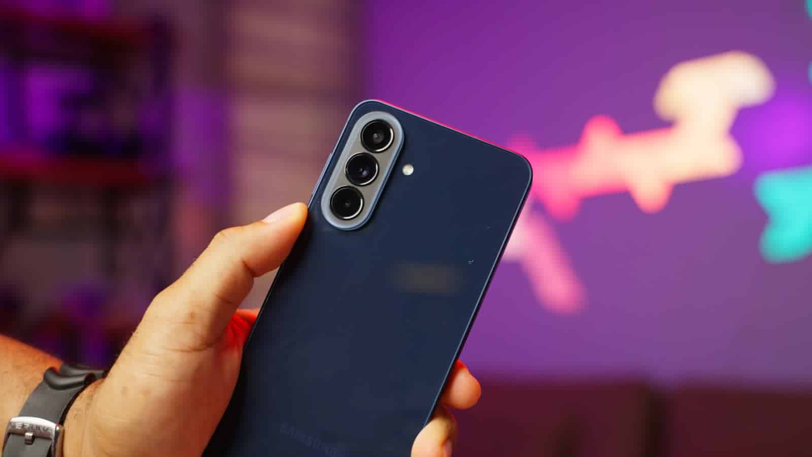 The back of the Samsung Galaxy A57 in navy, held in one hand